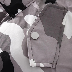 the picture is featuring camo snowsuit pockets with snap closure to make sure your little one's little things are secure in the pocket when your little one is actively playing around