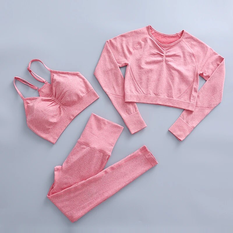 this picture is showing a color light pink yoga suit set consisting of 3 tems: a pasta top with bust suppert, a long sleeve top and a pair of pants with high waist to flatten your belly and butt push up effect.