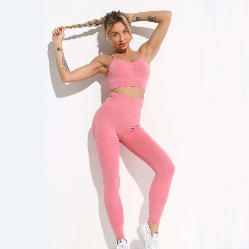 this picture is showing a beautiful young woman with gorgeous figure wearing a yoga suit color light pink. the yoga suit set consists of 2 tems: a pasta top and a pair of pants with high waist to flatten your belly and butt push up effect. front view