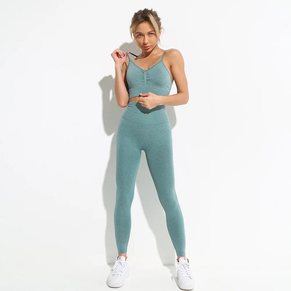 this picture is showing a beautiful young woman with gorgeous figure wearing a yoga suit color light green. the yoga suit set consists of a pasta top and a pair of pants with high waist to flatten your belly and butt push up effect.