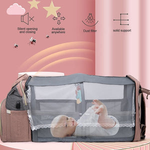 baby happily sleeping in a Diaper Bag Backpack transformed into a baby crib
