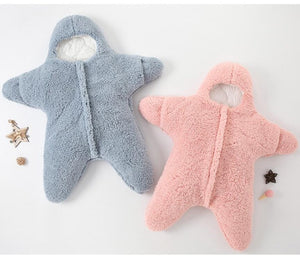 2 Baby Star Costumes | Winter One Pieces lying flt on a cosy white surface. one Baby Star Costume | Winter One Piece is light blue and the second one Baby Star Costume | Winter One Piece is light pink