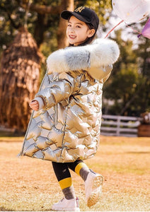 a smiling 7 year old girl wearing our knee long down jacket color silver metallic back view