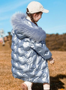 a cute 5 year old girl wearing long shiny winter coat color silver side view