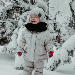 a cute 2 year old wearing a white Snow Toddler Puffer Jacket and Baby Winter Jumpsuit 