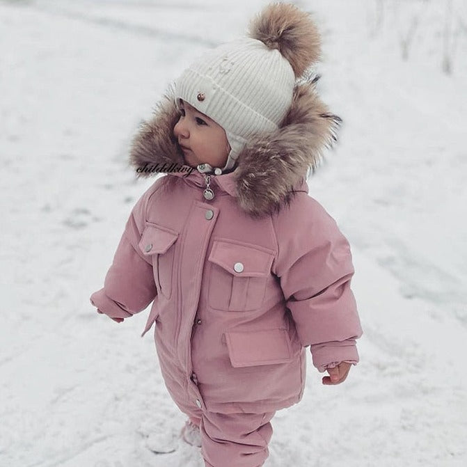 a cute little toddler girl wearing pink Snow Toddler Puffer Jacket and Baby Winter Jumpsuit